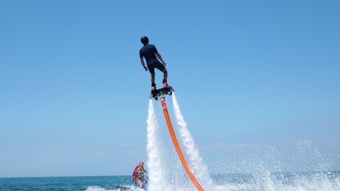 Стоковое видео: Water extreme sport. The guy is flying at the aquatic flyboard. A lot of water pressure. Slow motion.