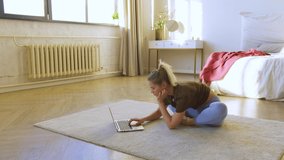 Young woman in prepares for strethching workout at home. She searches the tutorials for exercise videos.