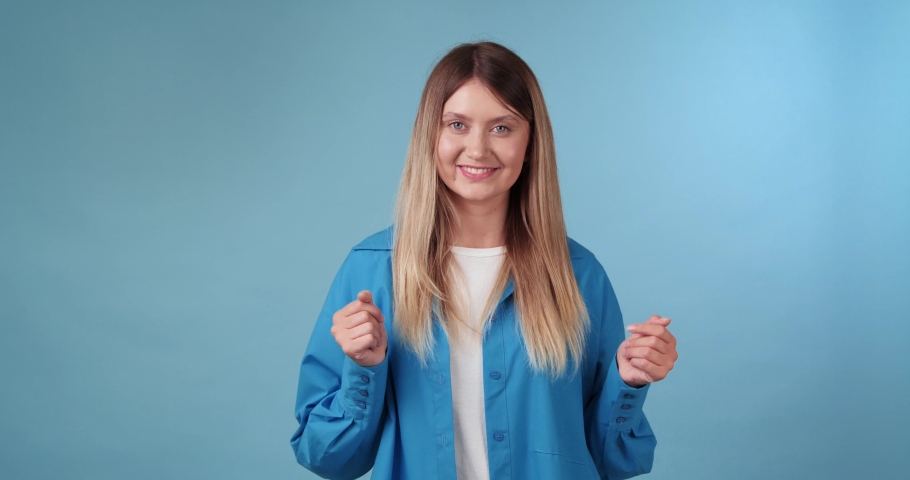 Happy young woman dancing on light blue background | Shutterstock HD Video #1097599685