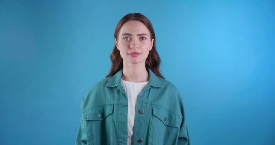 Beautiful young woman asking for something on light blue background | Shutterstock HD Video #1097599691