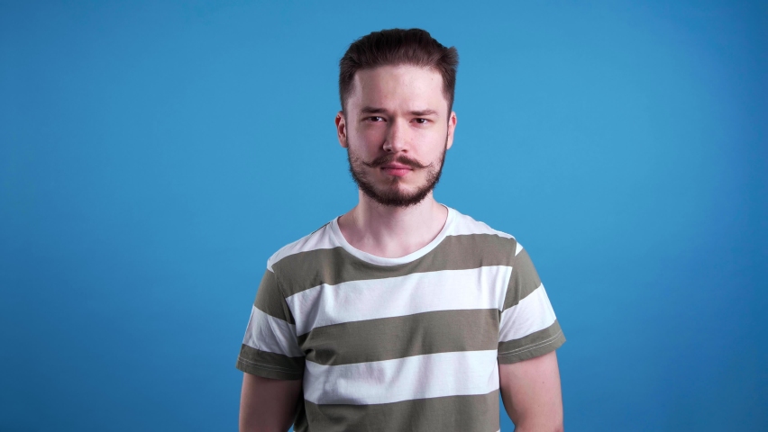 Angry young man on light blue background | Shutterstock HD Video #1097599693