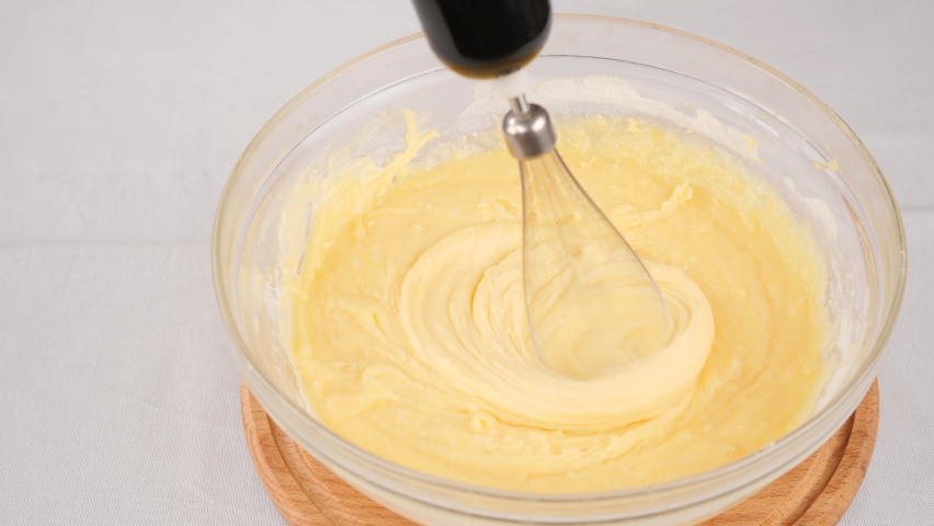 Kneading the dough with a whisk of a blender in bowl | Shutterstock HD Video #1097599809