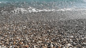 Sea wave crashes on a pebble beach. Video 19 seconds. Calm relaxing ocean shore footage