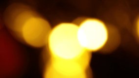 Yellow bokeh effect in darkness. Christmas lights. You can use it for video transitions. Copy space for text.