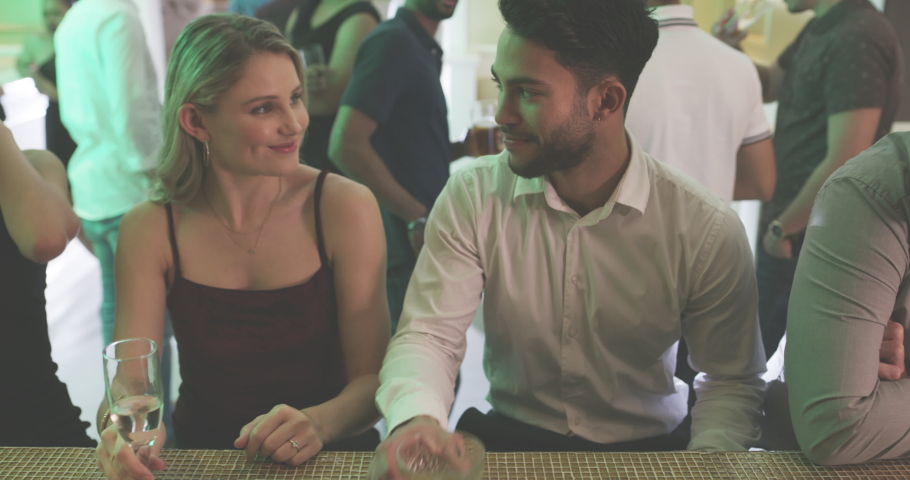 Party, nightclub and toast couple of friends with drink and champagne after social disco event. Glasses, celebration and love date of a man and women in a crown with alcohol and new year conversation