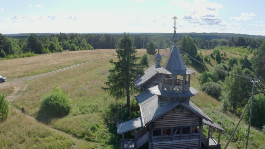 Old ancient wooden church in rural landscape, countryside. Desolated remote Orthodox Christian building, view from flying drone copter