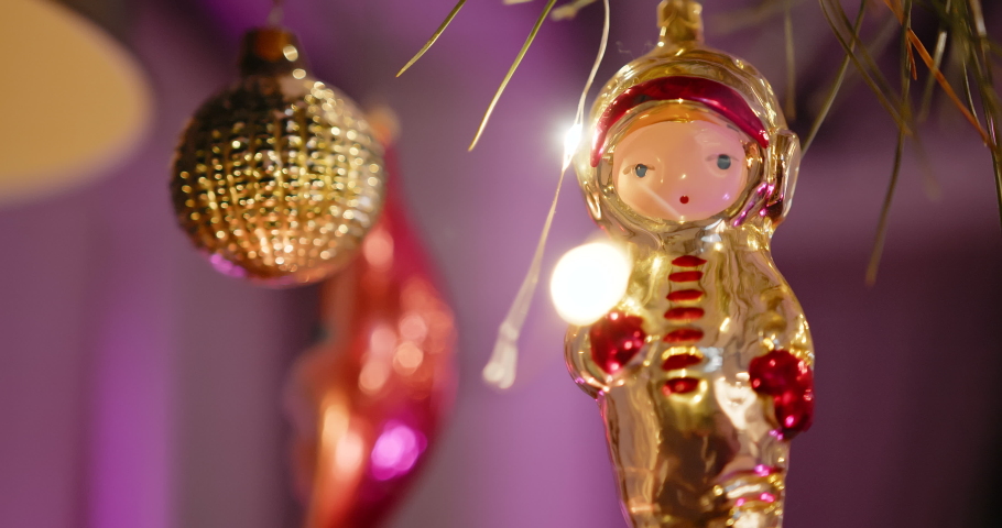 A new year toy hangs on branch of a Christmas tree in the form of an astronaut | Shutterstock HD Video #1097622851