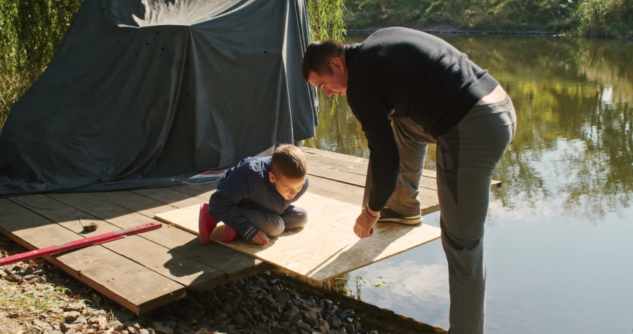 happy father and son building a tree house in the garden