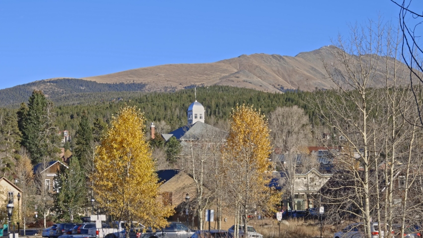 Wide angle town view of Breckenridge with Bald Mountain in the distance and yellow colored aspen trees. Filmed in the town of Breckenridge Colorado, during the winter.
