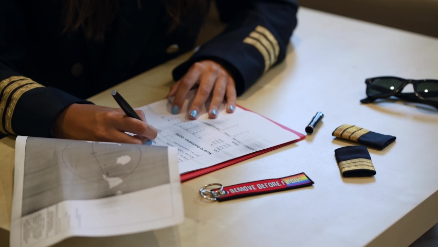 Unrecognizable female pilot preparing flight documentation on a tablet. Electronic flight bag. Selective focus