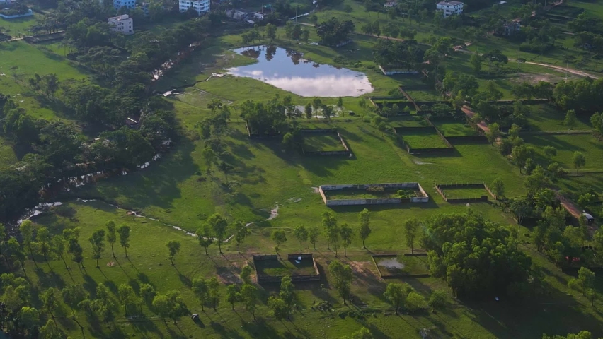 Aerial view of Real estate property plot land with lake in small town with buildings. Drone flying forward shot