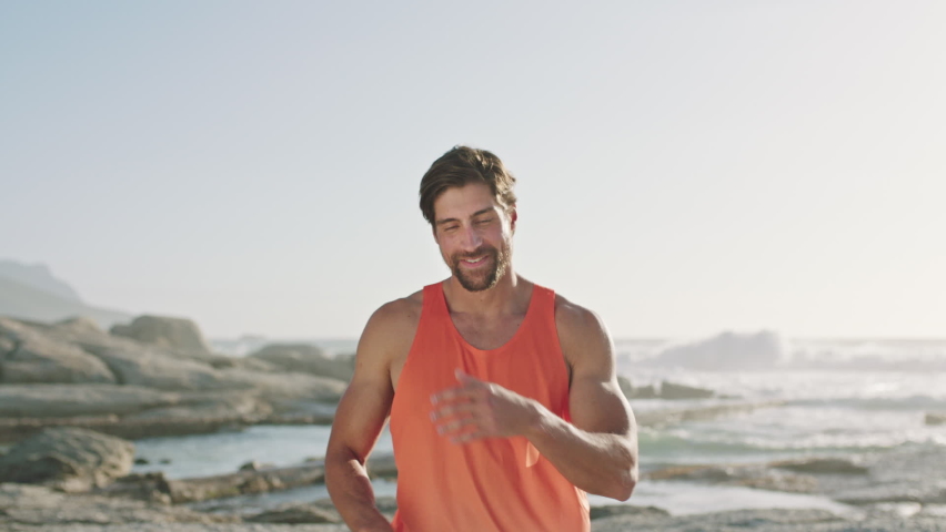 Beach, summer and fitness, portrait of man on vacation standing on rocks to relax on exercise break with smile in Indonesia. Travel, freedom and tropical ocean holiday with sunrise workout in Bali. | Shutterstock HD Video #1097632209