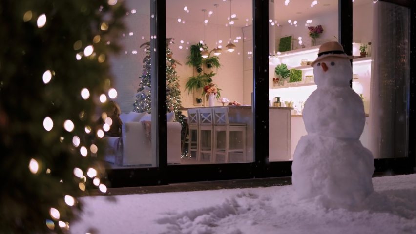 Kids having fun at home, with snowflakes falling outdoors in winter evening at the background. Cozy, decorated apartment on Christmas holidays | Shutterstock HD Video #1097636295