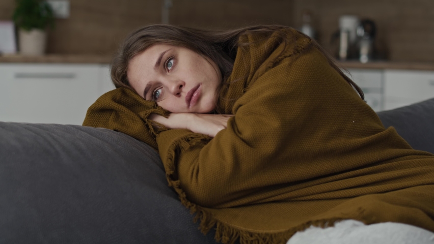 Caucasian sad woman sitting on the sofa and covering the blanket at home. Shot with RED helium camera in 8K.     | Shutterstock HD Video #1097638361