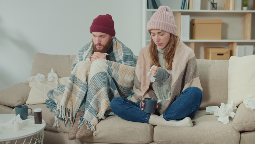 Unhealthy Couple Feeling Cold Fever Freezing Central Heating Problem at Home Covering With Plaid, Sneezing, Wiping Runny Nose with Paper Tissue, Feeling Unwell, Curing Flu with Pills | Shutterstock HD Video #1097639319