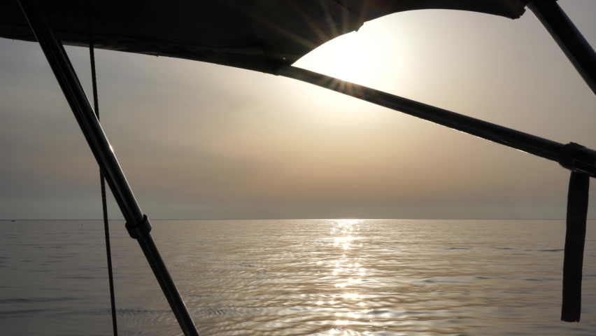 View from the yacht to the sunset at sea. Side view with green sea and waves. Concept, lifestyle and freedom. | Shutterstock HD Video #1097640309