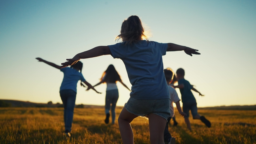 kids run in the park at sunset. friendly family children camp kid dream concept. a group of children run on the grass fun at the rays of the sun silhouette. childhood sunset dream teamwork concept Royalty-Free Stock Footage #1097640391