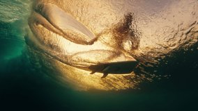 Surfer on the wave. Silhouette of a surfer riding the wave and touching the water. Underwater view of a surfer at sunset - Powered by Shutterstock - Get 15% off with code: PIKWIZARD15