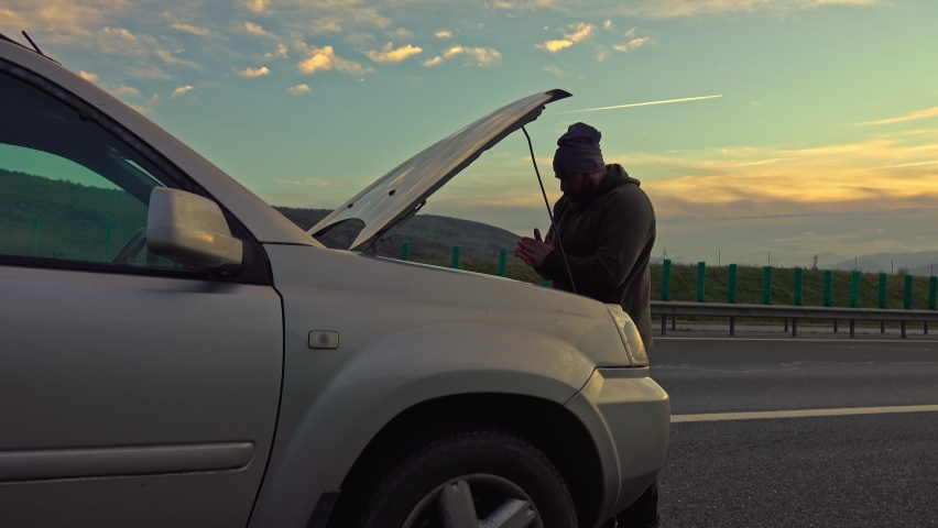 Middle age man trying to fix car breakdown or engine failure and waiting for towing service for help car accident on the road. Roadside assistance concept. Royalty-Free Stock Footage #1097643515