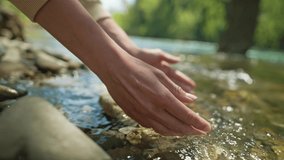close up slow motion female hands taking fresh cold clean water in palms from mountain river. wide angle view, focus on palms. clean and safety invironment concept. water resources, earth, environment - Powered by Shutterstock - Get 15% off with code: PIKWIZARD15
