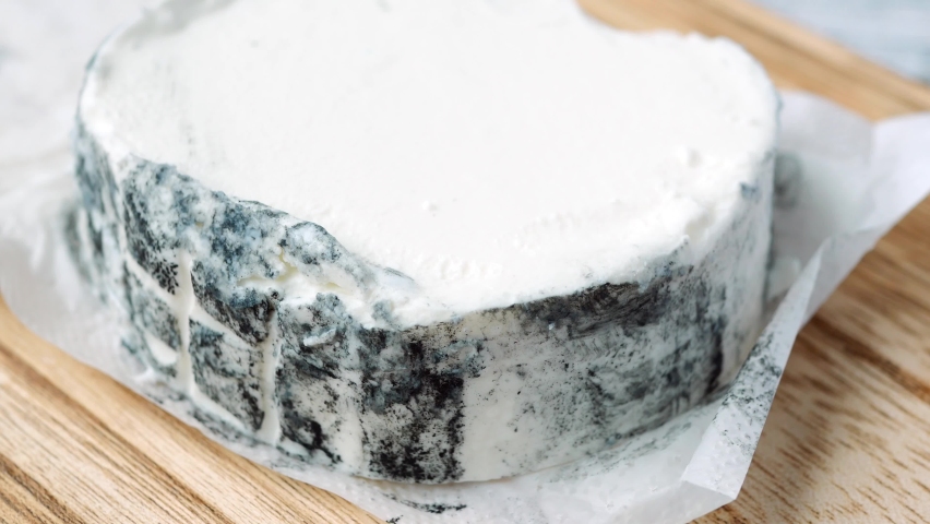 cutting fresh goat cheese with a spoon 