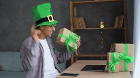 Young happy arabic man in leprechaun hat sitting at home in living room with laptop computer on St.Patrick's Day, celebrating online, making video conference - Powered by Shutterstock - Get 15% off with code: PIKWIZARD15