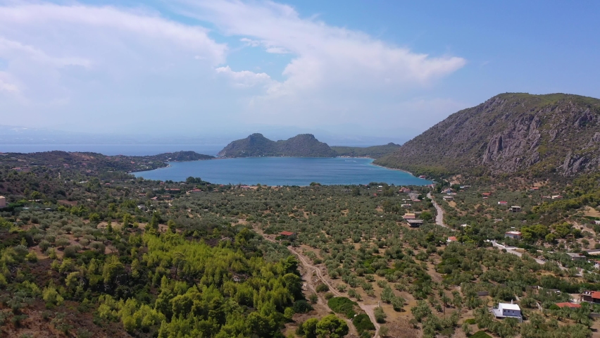 Aerial drone video of scenic lake Vouliagmeni in Corinthia near famous lighthouse of Heraion and city of Loutraki featuring crystal clear turquoise beach and calm waters, Perachora, Greece