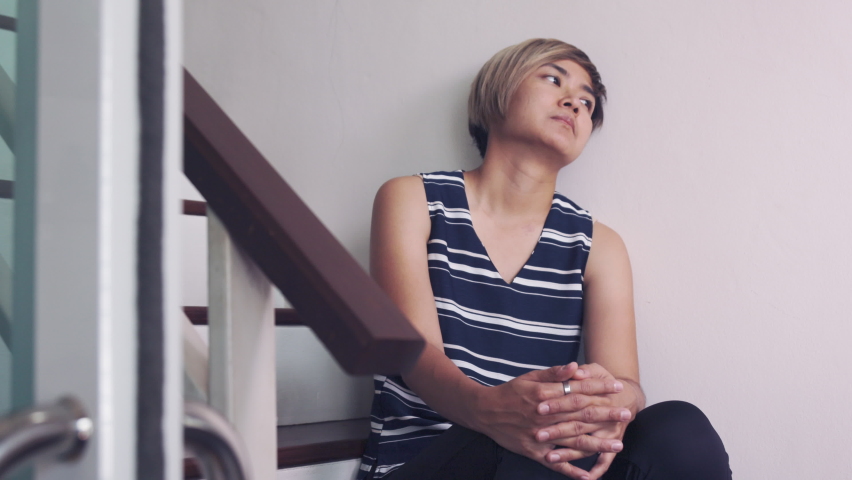 30s Asian woman who expresses her depression and stressful emotion alone on ladder her house shows concept of mental illness and emotional suffer from either economic crisis or relationship problem. | Shutterstock HD Video #1097650493