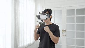 Asian man enjoy playing virtual reality games, Healthy young man wearing VR glasses exercising. - Powered by Shutterstock - Get 15% off with code: PIKWIZARD15