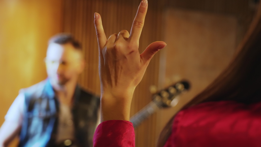 Hand raised showing a heavy metal rock sign. High quality 4k footage