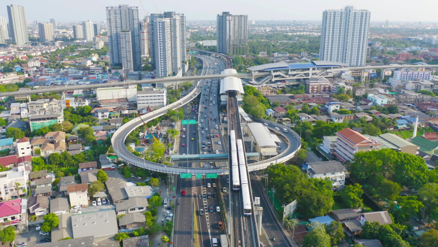Aerial view of Bangkok Railway terminal station, BTS with skyscraper buildings in urban city, Bangkok downtown skyline, Thailand. Cars on traffic street road on highways. Royalty-Free Stock Footage #1097656135