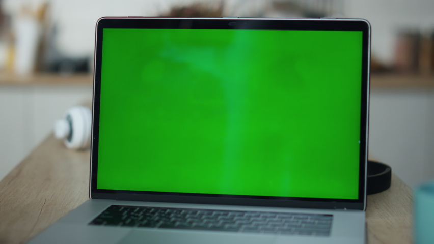 Closeup greenscreen laptop computer on office table. Unknown guy hand putting coffee cup on table near chromakey screen. Freelancer doing remote job on mockup display. Technology gadget concept. Royalty-Free Stock Footage #1097665471