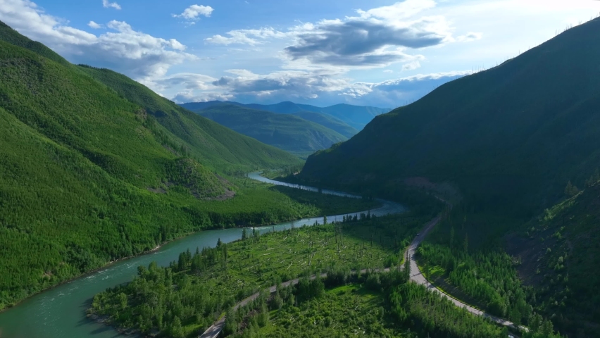Blue River Through Lush Green Mountains Near Glacier National Park In Montana, USA. aerial