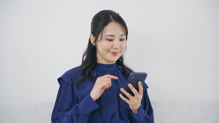 Young Asian woman using a smart phone in the room. Royalty-Free Stock Footage #1097676291