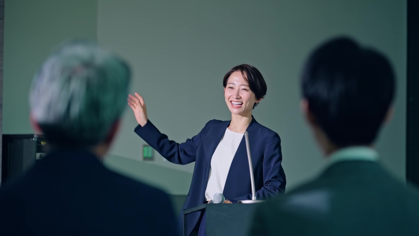 Asian middle aged woman giving a lecture and audience. Royalty-Free Stock Footage #1097680683
