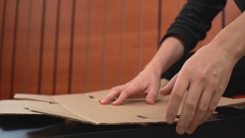 The man himself folds a cardboard box according to the brochure. High-quality FullHD video recording. real-time video | Shutterstock HD Video #1097682439