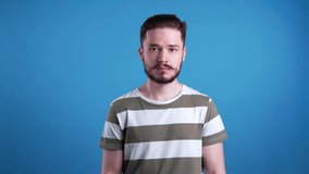 Unhappy young man on light blue background