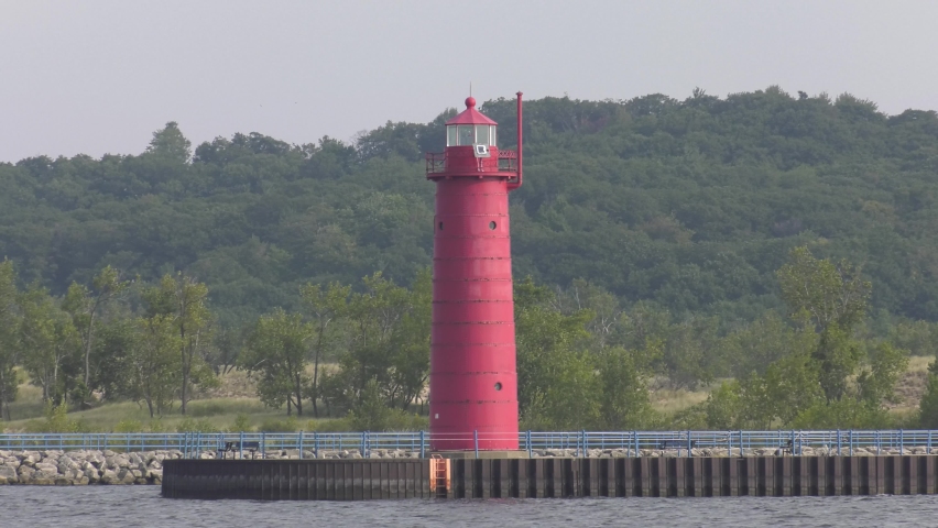 Lighthouse at Muskegon on Lake Michigan. Close static shot from the end of the breakwater looking back at the shoreline.