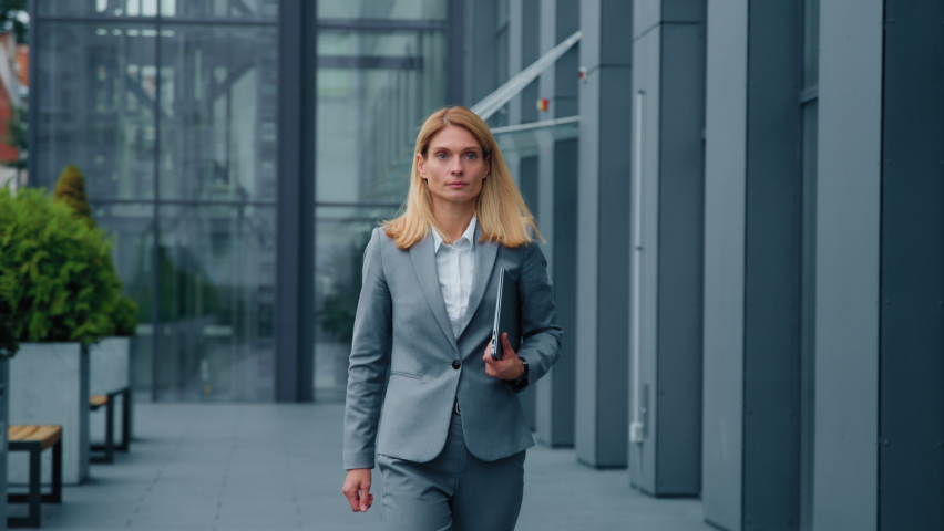 Successful confident caucasian businesswoman corporate employee walk near office building looks around happy funny excited woman doing winner gesture yes gets new dream job rejoices in success victory Royalty-Free Stock Footage #1097698955