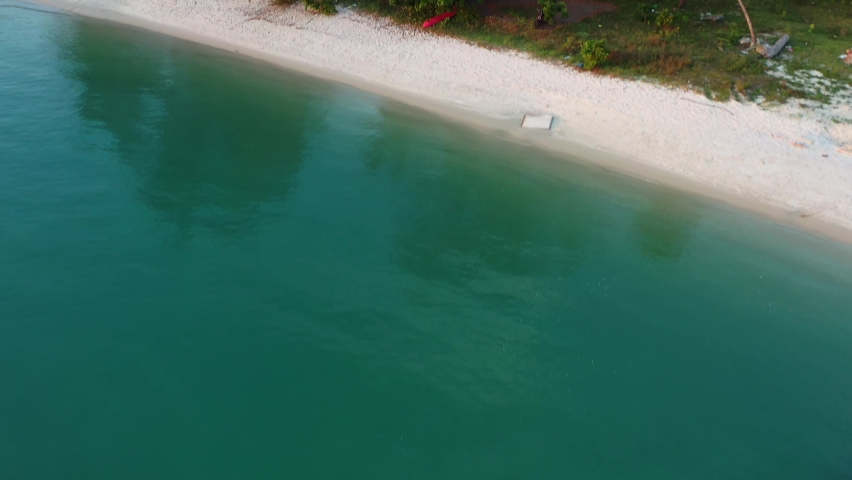 Aerial tilt up reveal shot capturing a grand 5-star luxury beachfront resort hotel with private swimming pool and beach access, the Danna Langkawi, tropical island paradise, Malaysia, Southeast Asia.