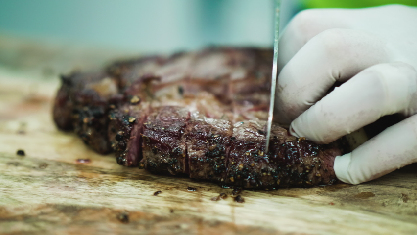 Cutting beef steak on board