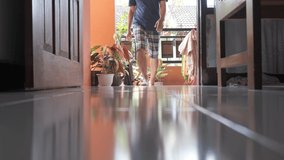A man is entering the door of a house, close up of footsteps towards the camera, frog eye view