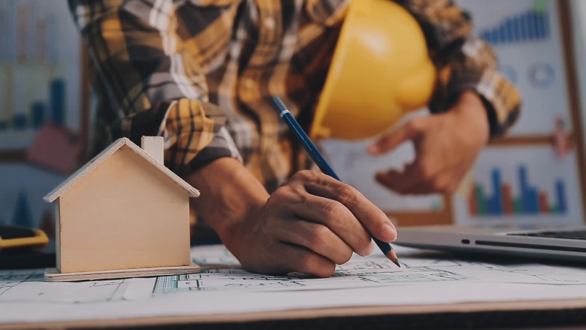 Two colleagues discussing data working and tablet, laptop with on on architectural project at construction site at desk in office | Shutterstock HD Video #1097710205