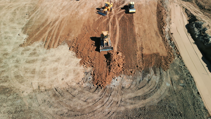  A many bulldozer levels a plot of land for development. Drone top down footage. | Shutterstock HD Video #1097711017