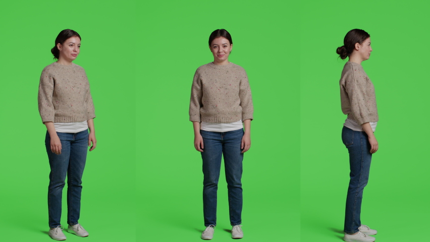 Young adult standing over full body greenscreen background, posing in front of camera. Woman feeling confident and relaxed sitting on green screen backdrop in studio, casual facial expressions.