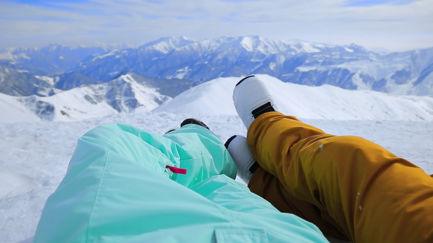POV couple snowboarder legs having date outdoor. First person view. Happy young people kiss in snowy mountains. Joyful man and woman spending winter Christmas holiday together. Active sport concept | Shutterstock HD Video #1097711717
