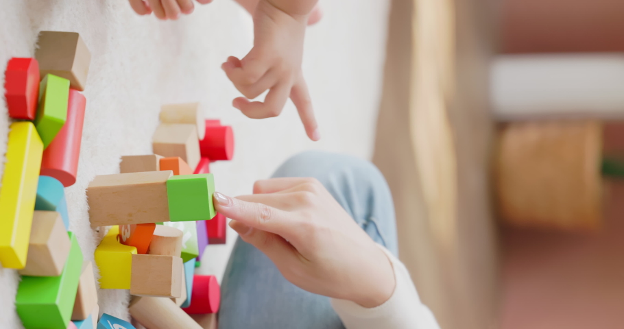 Vertical close up - hands of asian happy mother and her child son are playing with building blocks together in living room at home | Shutterstock HD Video #1097711795