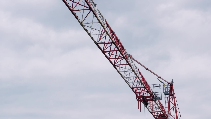 High crane works on building site with house. Crane tower in construction. Close up view of the crane tower lifting material in building site. Industry construction | Shutterstock HD Video #1097712291
