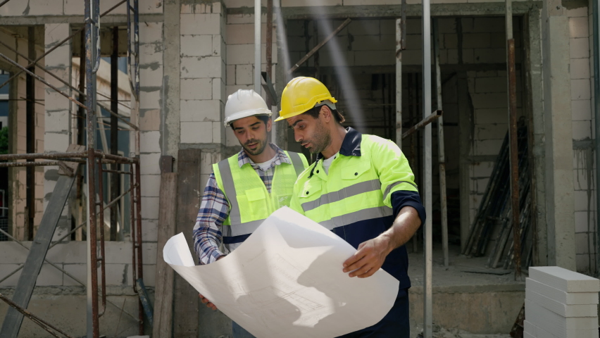 Construction engineer and foreman walking holding blueprints walking inspect at construction site to meet specs, construction concept, engineer, business | Shutterstock HD Video #1097712339