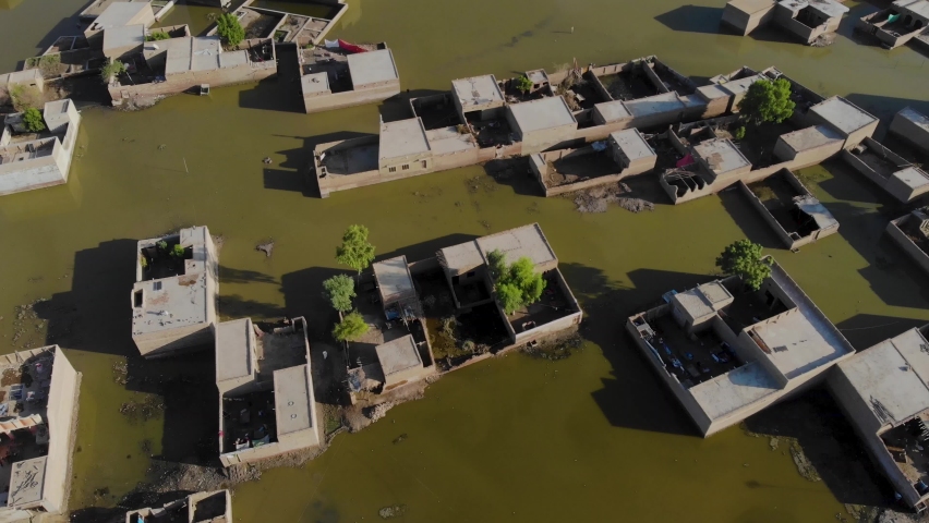 Aerial View Of Rural Buildings Under Floodwater In Sindh. Dolly Back, Tilt Up Reveal  Royalty-Free Stock Footage #1097714409